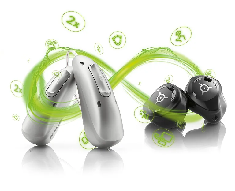 Zwei Hörgeräte-Modelle vor grünem Unendlichkeits-Schwung und Münzsymbolen auf schwarzem Hintergrund.